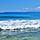 Beach view of a boat driving by the Hawaiian Island of Niihau nicknamed the Forbidden Isle. Hawaii