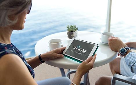 OA, Oasis of the Seas, Royal Suite Class, GENIE shoot, couple on balcony having coffee, woman holding tablet with VOOM interface, internet, wifi, technology, broadband, web, connectivity, ocean in background,
 
NOTE: This version has the revised and updated VOOM logo as of March 2017, now with trademark symbol instead of service mark. (This change is very small in the photo, not really visible in small web images.) 

This file is a jpeg. For high-res tif, open Related Assets container below.