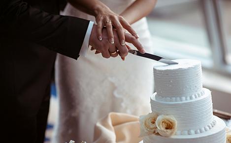A bride and a groom is cutting their wedding cake. beautiful cake. nicel light. wedding concept