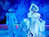 Woman performer in a white and blue snowflake costume during the Frozen in Time ice skating show on Oasis.