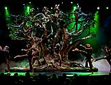 Performers forming a tree on stage with green lights during the Blue Planet Cruise Show on Allure of the Seas