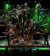 Performers forming a tree on stage with green lights during the Blue Planet Cruise Show on Allure of the Seas