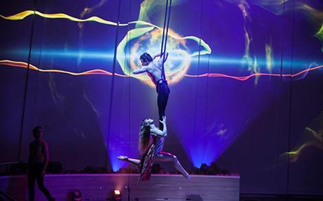 Couple performers doing aerial tricks with blue lighting during the acrobat show Starwater on Quantum.