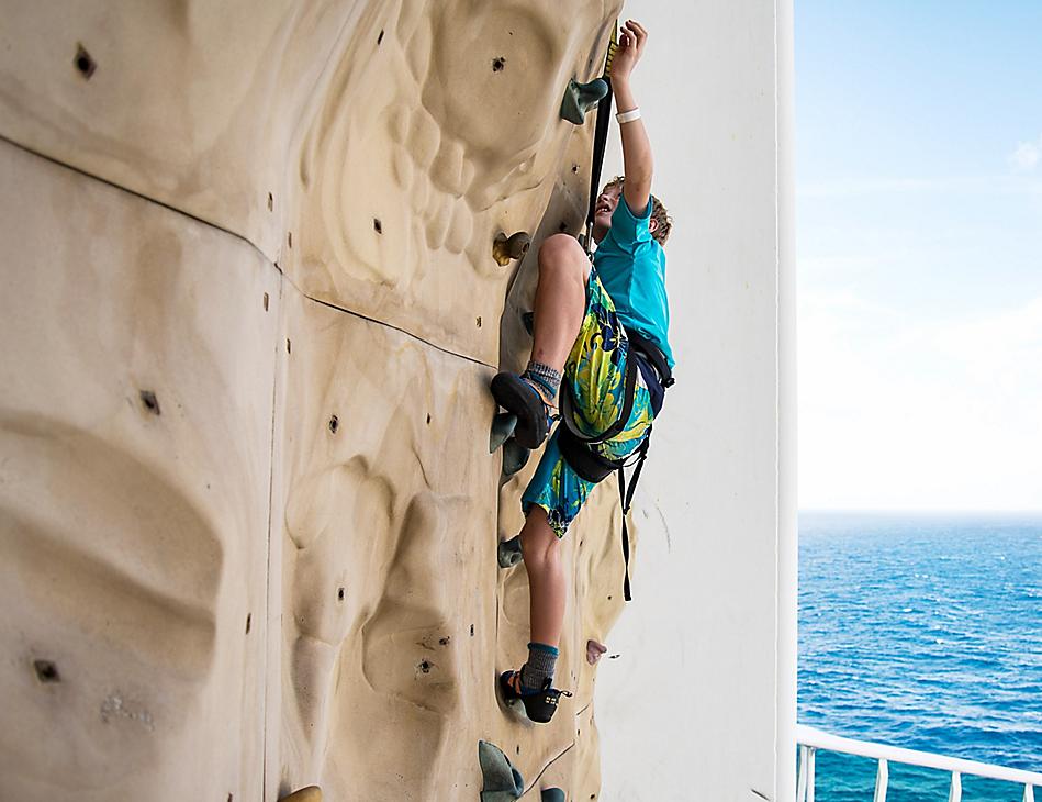 Young Boy Climbing on the Rock Wall 
