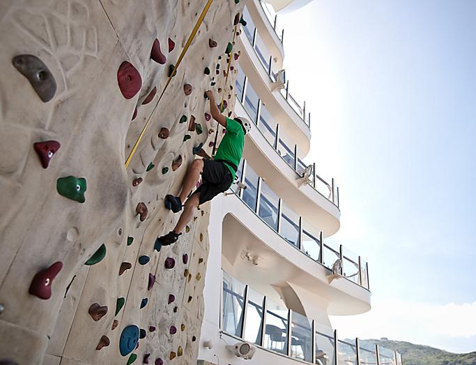 Man Climbing Rock Wall On Board Day Time