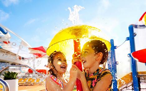 WN, Wonder of the Seas, two young girls under yellow dome fountain, SplashAway Bay, fun, kids, children, water droplets, spray,
