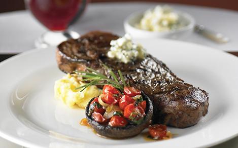 12 oz Grilled NY-Strip Steak served at the fine dining steakhouse, Chops Grille. One of the best cruise line restaurants.