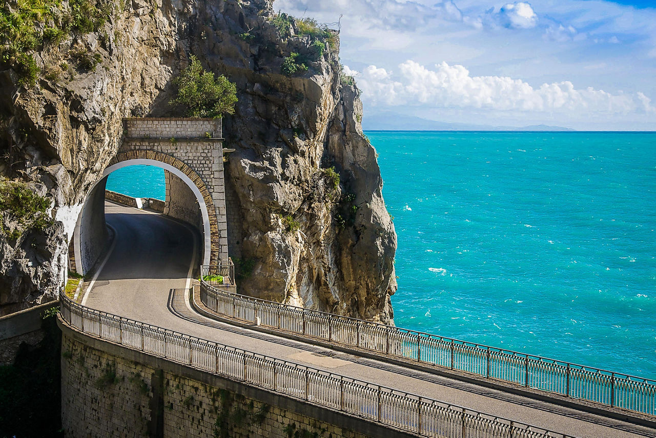 A scenic road with a tunnel through a mountain in the Amalfi Coast