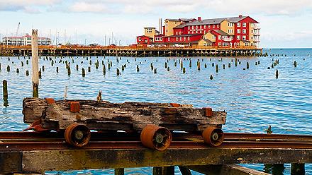 A rusted rail cart with the Cannery Pier in the distance