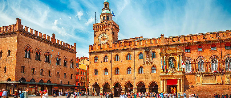 Piazza Maggiore with big clock and blue sky in Bologna, Italy