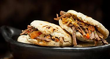 Two arepas rellenas filled with shredded beef