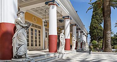 Statues in front of the pillars of the Achillion Palace in Corfu, Greece