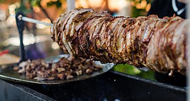 Cooking grilled meat shawarma to make hot kebabs, a typical street food in Dubai