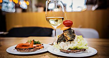 A fish sandwich paired with a glass on wine in Finland