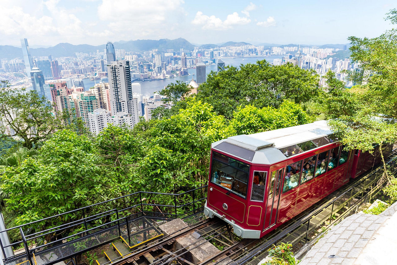 The Victoria peak tram arriving at a station overlooking the skyline in Hong Kong, China