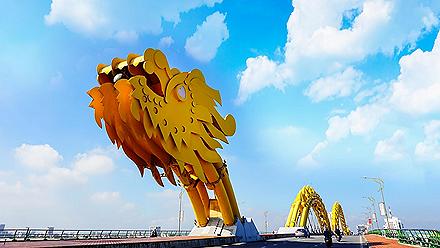 A yellow giant dragon bridge on a beautiful cloudy day in Vietnam