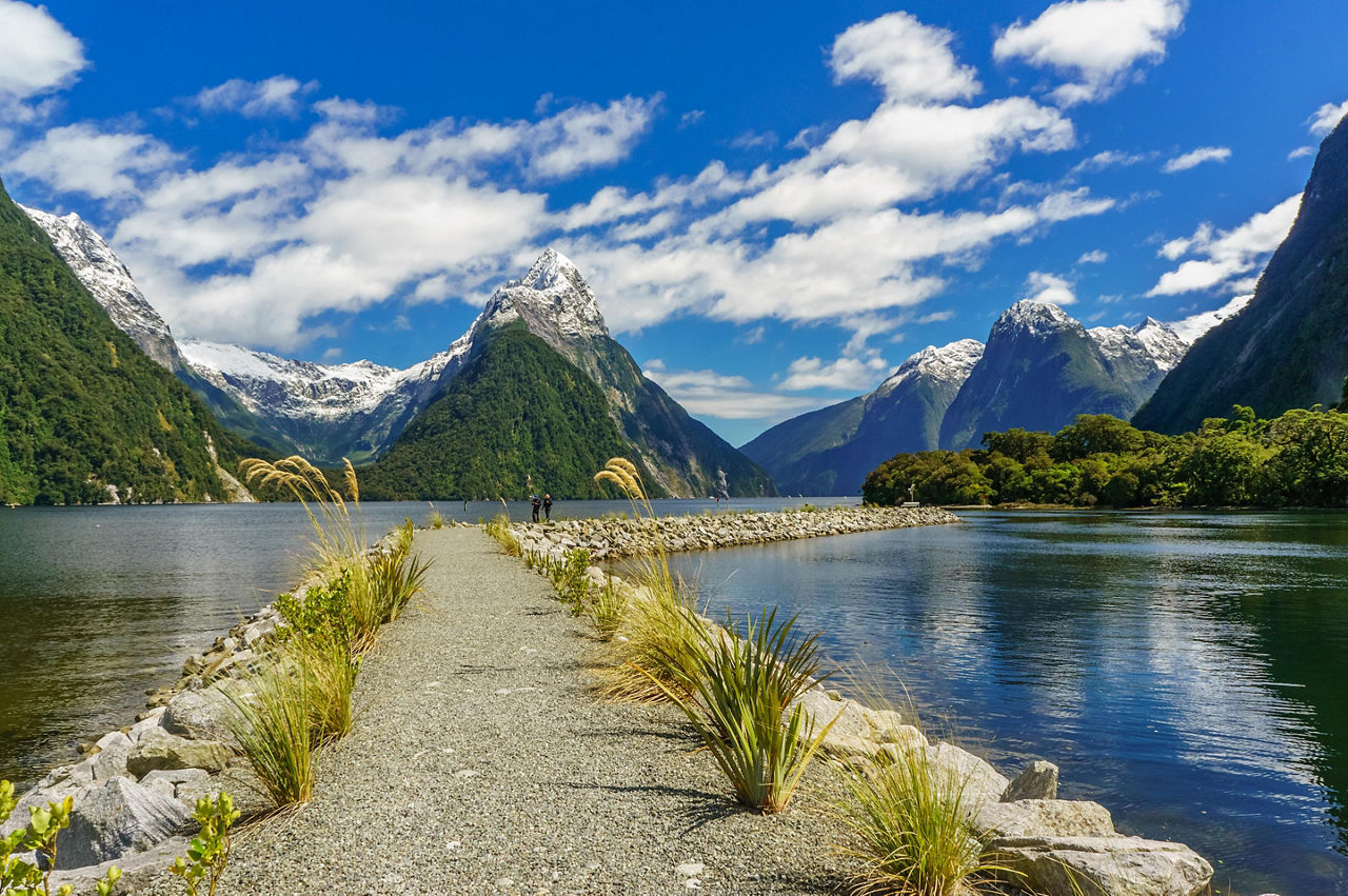 A pathway through a naturesque body of water with mountains around in New Zealand