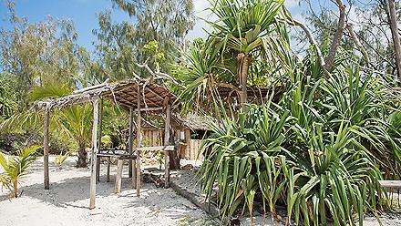 Thatched roof shelter on the beach with tropical plants and trees on Mystery Island, Vanuatu