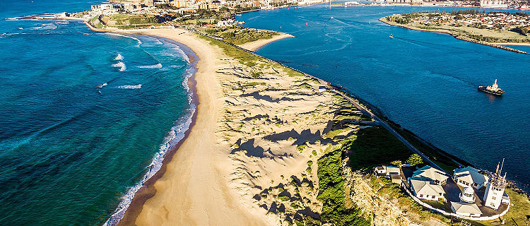 Nobby's beach and lighthouse in an aerial shot of Newcastle, Australia