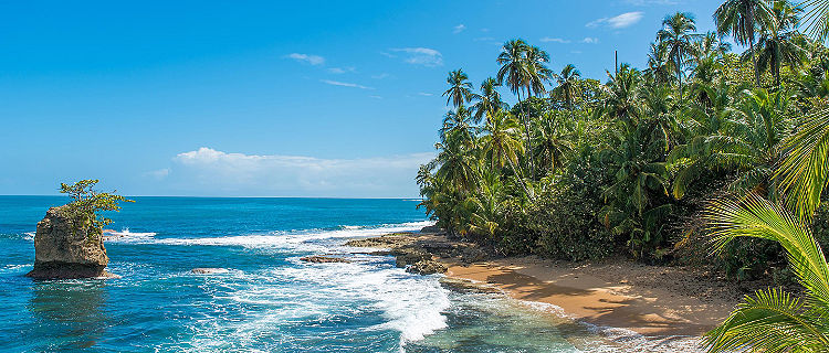 Wild waves hitting the shore of Manzanillo beach on a beautiful sunny day, near Puerto Limon, Costa Rica