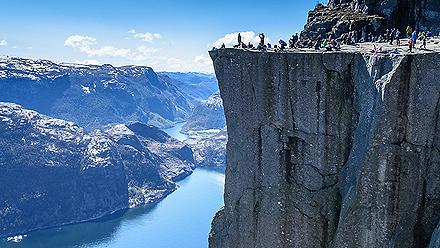 Side view of people standing on Cliff Preikestolen at the Lysefjord in Norway