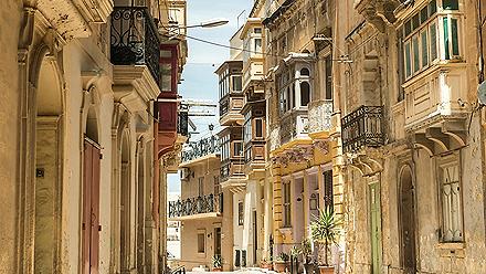 Narrow street with traditional balconies in Valletta, Malta