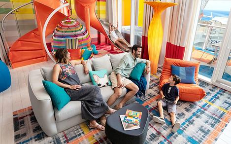A family enjoying the Ultimate Family Suite while a girl goes down the slide