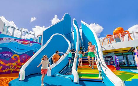 WN, Wonder of the Seas, family fun at Playscape, daytime, mother and daughter on stairs, one child running, dad watching daughter on ropes, blue colors, octopus statue in right background,