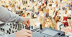 DJ playing music with a turntable at beach party festival. Miami. 