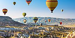 Cappadocia hot air balloon ride & tourist attraction in mountains above Turkey.