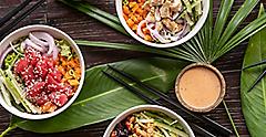 Variety of healthy organic Hawaiian foods served on wooden table with tropical leaves. Hawaii.