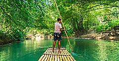 Traveler rowing bamboo raft, whilst on a cruise vacation in Montego Bay. Jamaica.