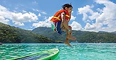 Young Boy Jumping inside Ocean after Kayaking
