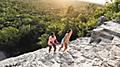 Couple Climbing Up Ruins in Mexico During Romantic Vacation