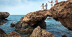 Family Jumping Through Rocks, Oranjestad, Aruba