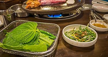 Enjoy some local fire-grilled black pork on Jeju Island.