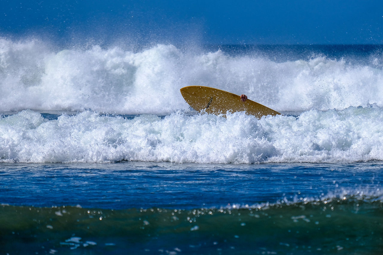 Surfer caught in waves in El Yankee Beach, Nicaragua
