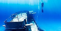 Free diver swimming up from a large underwater shipwreck. The Caribbean.