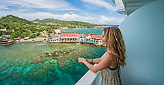 Woman looking at ocean from cruise ship in a white sun dress. The Caribbean.