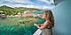 Woman looking at ocean from cruise ship in a white sun dress. The Caribbean.