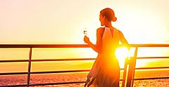 Cruise ship traveler drinking glass of champagne with the sunset.